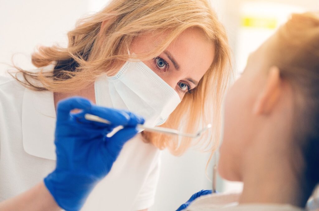 Zahnärztin untersucht die Zähne einer Patientin 